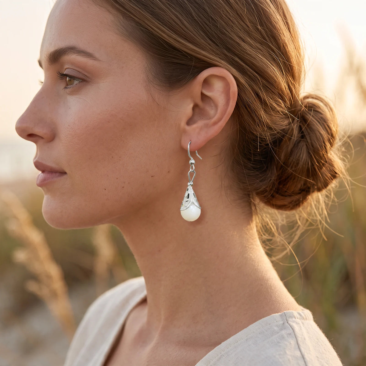 Boucle d'oreille nacre à calotte filigrane en acier inoxydable, portée à l'oreille