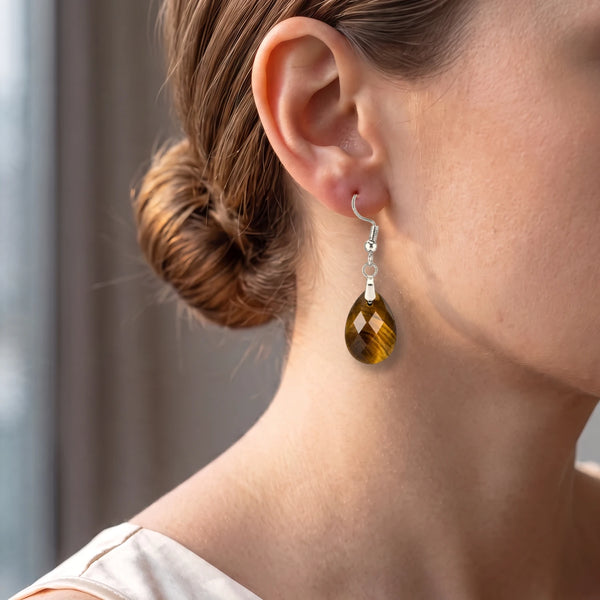 Boucle d'oreille œil de tigre portée par une femme, goutte facettée sur crochet acier argenté
