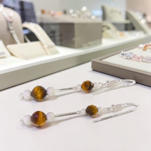 Gros plan perles oeil de tigre facettées 6mm et 8mm boucles Alnilam