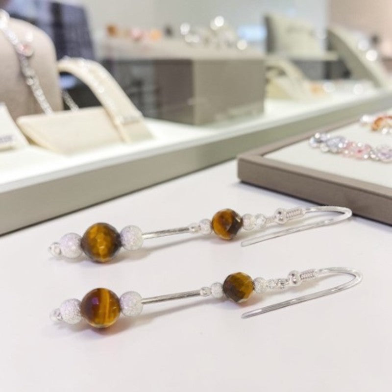 Gros plan perles oeil de tigre facettées 6mm et 8mm boucles Alnilam