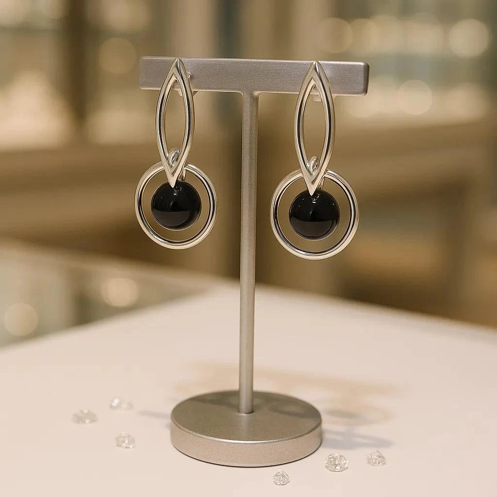 Boucles d'oreilles Denebola en onyx noir et argent 925 rhodié, présentées sur un support