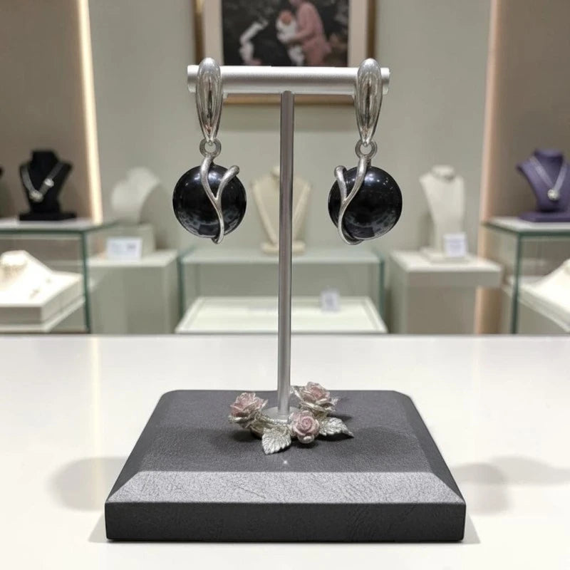 Boucles d'oreilles Antarès en onyx noir et argent 925 rhodié, présentées sur un support