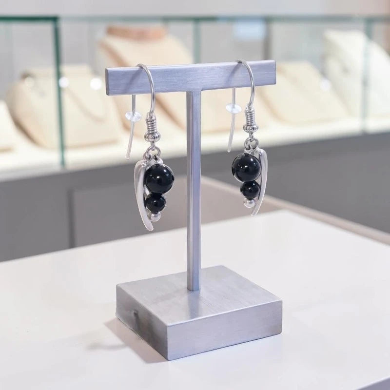 Boucles d'oreilles Alhena en onyx noir et argent 925 rhodié, présentées sur un support