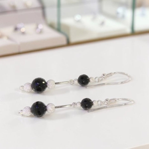Gros plan perles onyx noir facettées 6mm et 8mm boucles Mintaka