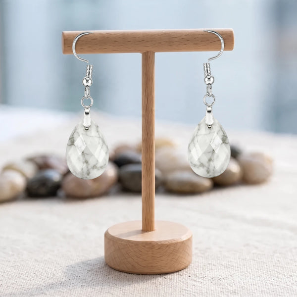Boucles d'oreilles pierre blanche, goutte de howlite veinée facettée sur crochet argenté, sur un support en bois