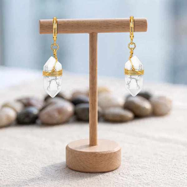 Boucles d'oreilles pierre blanche veinée de gris, pointe d'howlite et fil doré, créoles sur un présentoir en bois