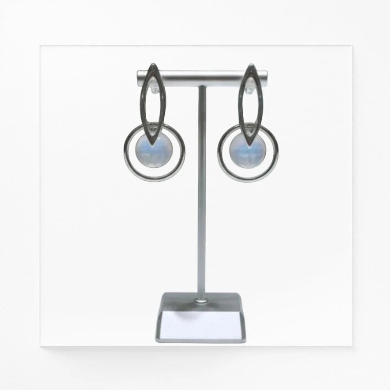 Boucles d'oreilles Céléno en pierre de lune et argent 925 rhodié, présentées sur un support