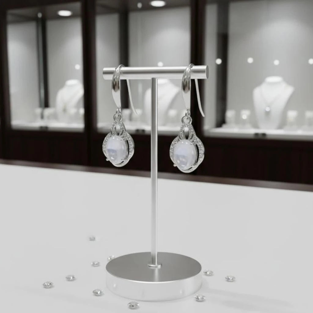 Boucles d'oreilles Alphératz en pierre de lune et argent 925 rhodié, présentées sur un support