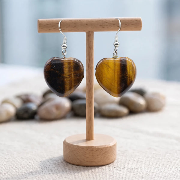 Boucles d'oreilles pierre marron dorée, cœur en œil de tigre naturel sur crochet argenté, sur un support en bois
