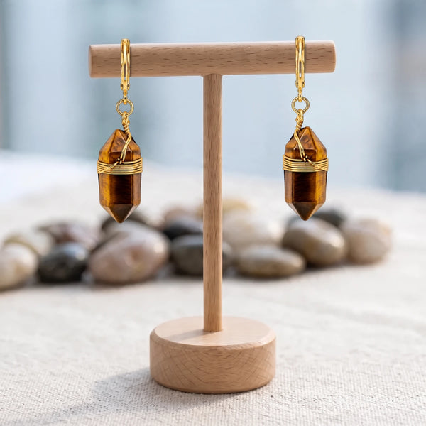Boucles d'oreilles pierre marron, pointe d'œil de tigre aux reflets dorés, créoles sur un présentoir en bois