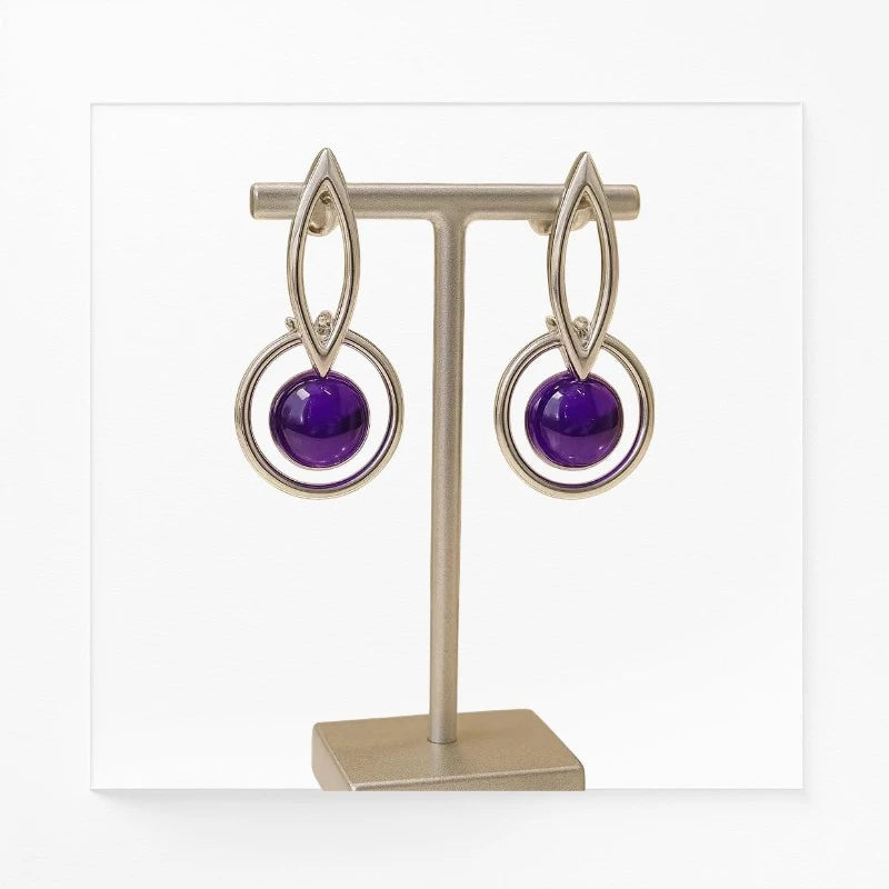 Boucles d'oreilles Naos en améthyste et argent 925, présentées sur un présentoir à bijoux