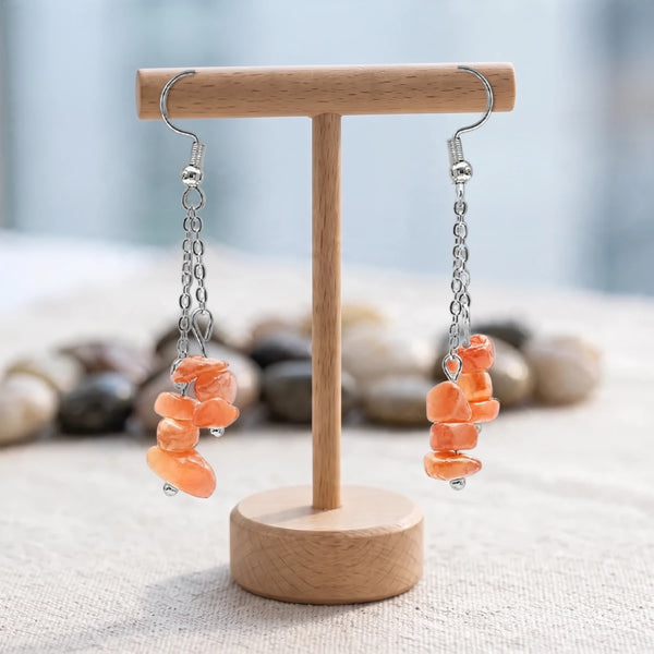Boucles d'oreilles pierre orange, chips baroques de cornaline sur double chaîne acier argenté, sur un support en bois