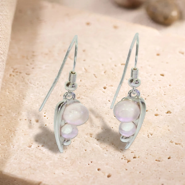 Boucles d'oreilles crochet en argent 925 rhodié, feuille et deux perles de quartz rose, posées à plat sur du travertin