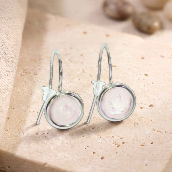 Boucles d'oreilles pendantes en quartz rose, pierre ronde sertie sur crochet en argent 925 rhodié, posées sur du travertin