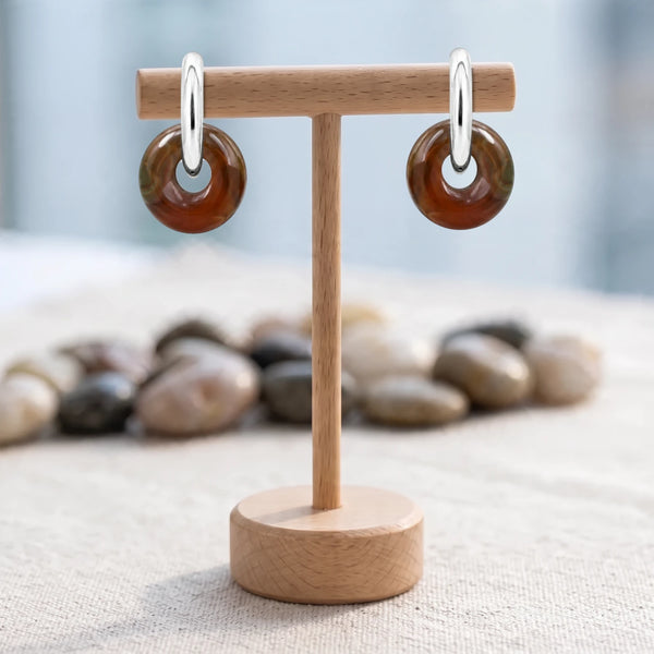 Boucles d'oreilles pierre rouge, donut d'agate indienne 15 mm sur créole acier argenté, sur un support en bois