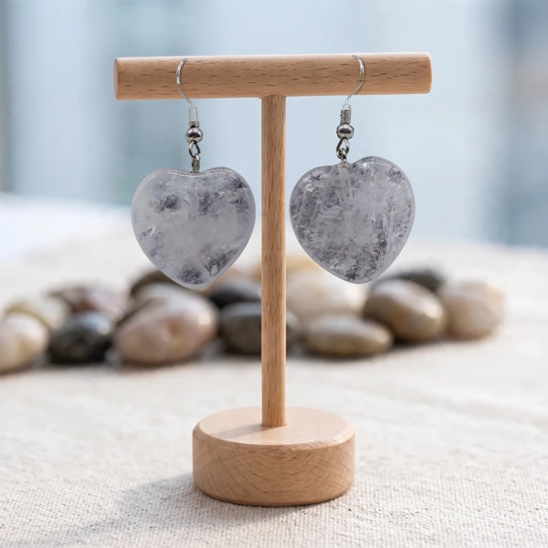 Boucles d'oreilles pierre transparente, cœur en cristal de roche naturel sur crochet argenté, sur un support en bois