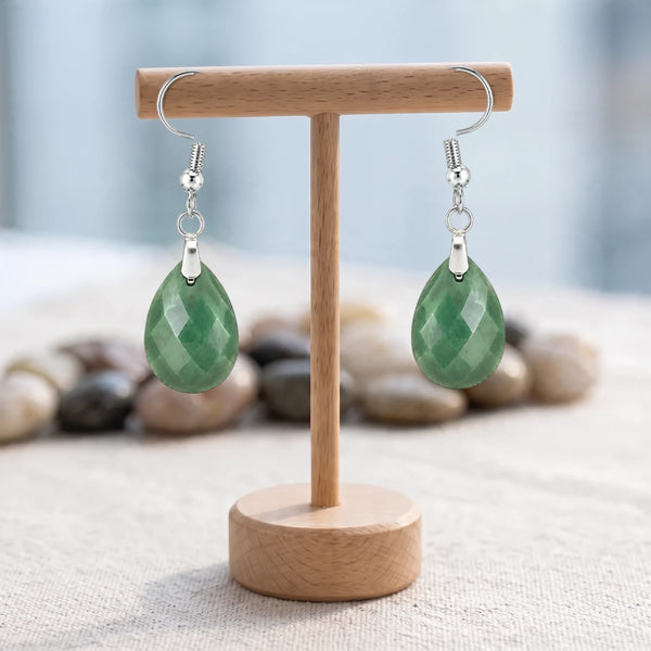 Boucles d'oreilles pierre verte, goutte d'aventurine facettée sur crochet acier argenté, sur un support en bois