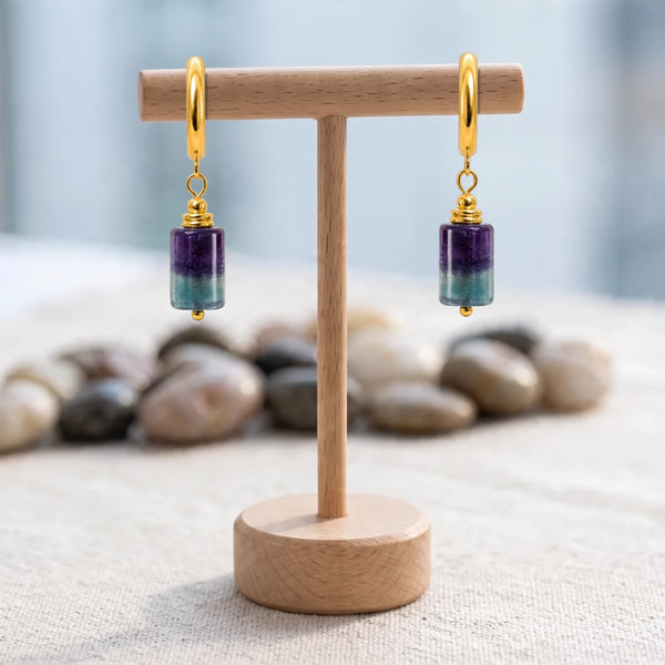 Boucles d'oreilles pierre violette et verte, tube de fluorite multicolore sur créole dorée, sur un support en bois