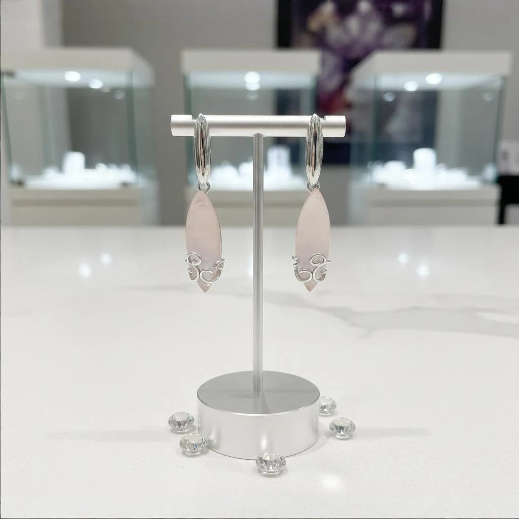Boucles d'oreilles Alderamin en quartz rose et argent 925 rhodié, présentées sur un support
