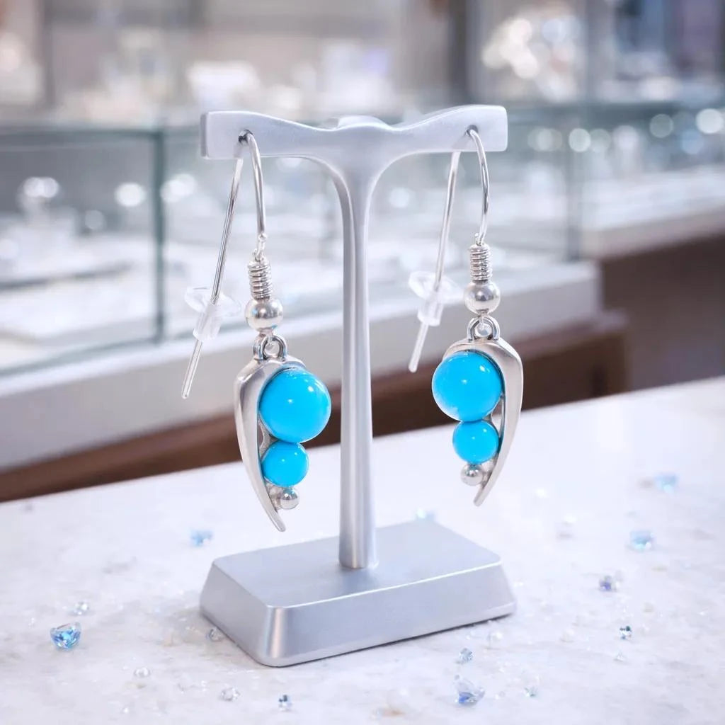 Boucles d'oreilles Alphard en turquoise et argent 925 rhodié, présentées sur un support