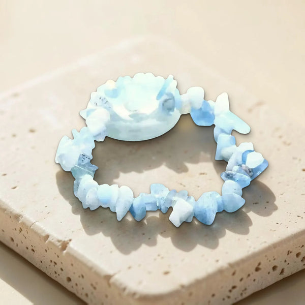 Bracelet aigue-marine et pierre roulée bleu clair, photo réelle du bijou sur travertin