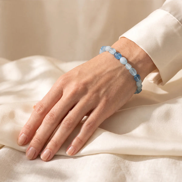 Bracelet aigue-marine porté par une femme, pierres roulées bleu glacier au poignet