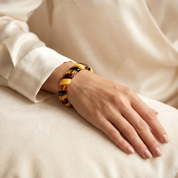 Bracelet manchette en plaquettes d'ambre jaune et cognac porté par une femme