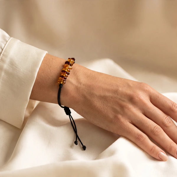 Bracelet cordon ambre miel porté au poignet d'une femme, nœud coulissant réglable