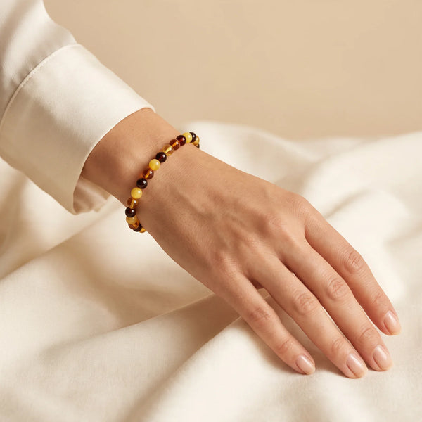 Bracelet fin en ambre multicolore porté par une femme, petites perles rondes