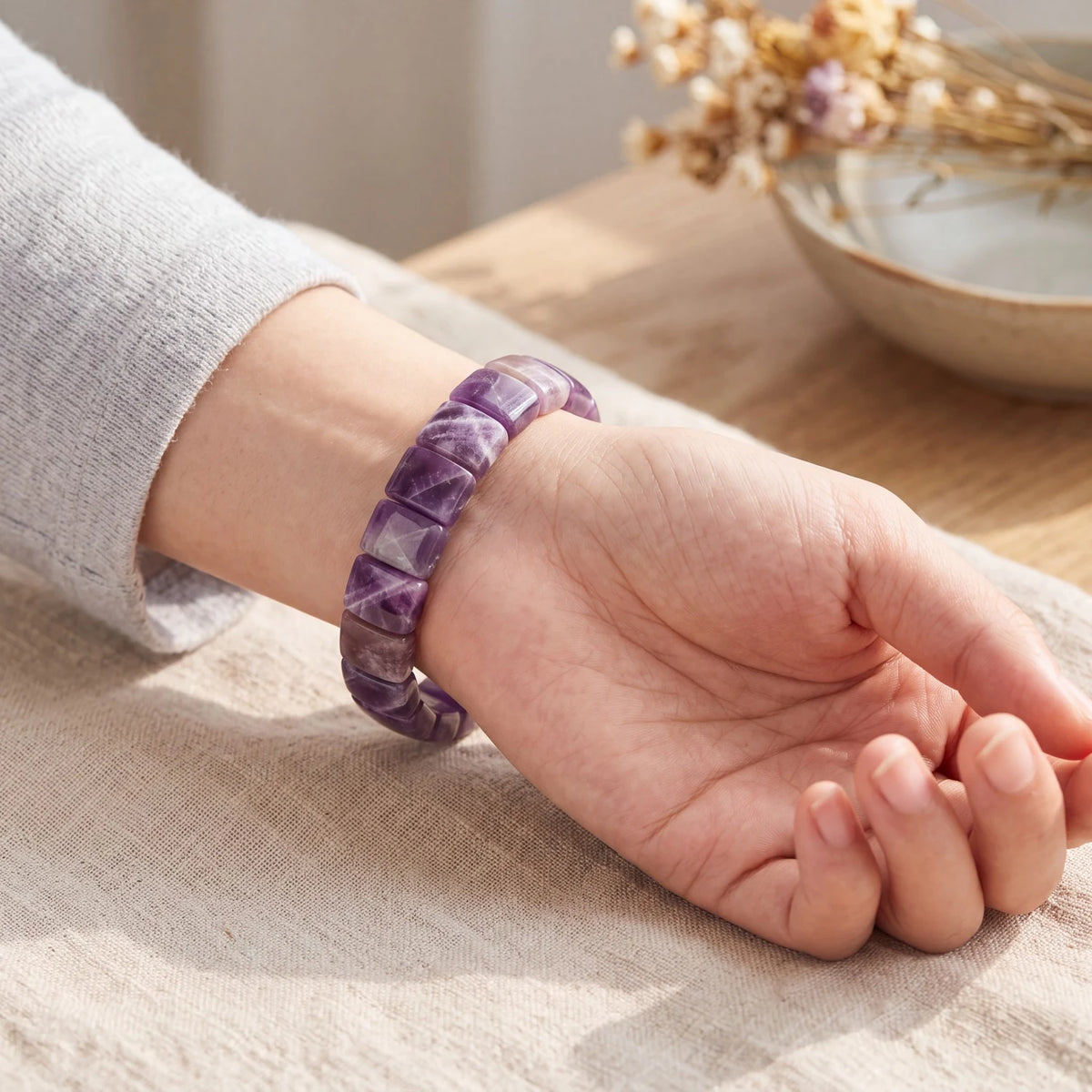Bracelet améthyste chevron femme porté au poignet, plaques violettes à bandes blanches