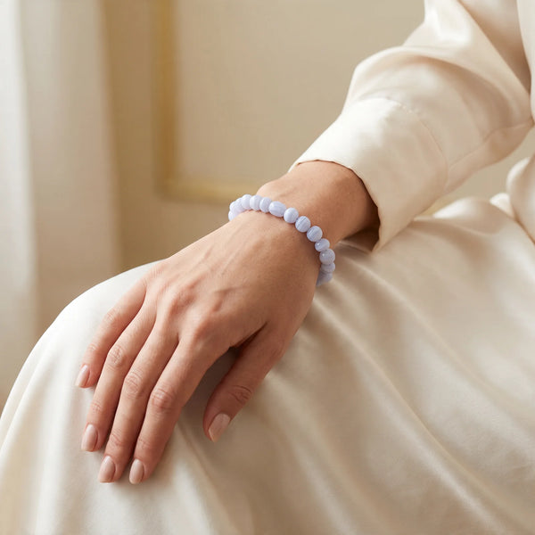 Bracelet en calcédoine bleue porté par une femme, pierres roulées bleu pastel au poignet