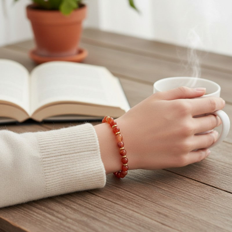 Bracelet Cornaline AURA® porté au poignet, bracelet fin doré en pierre naturelle