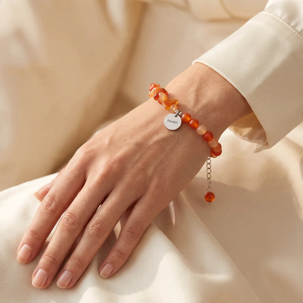 Bracelet pierre orange en cornaline porté au poignet d'une femme, chips et perles de 6 mm