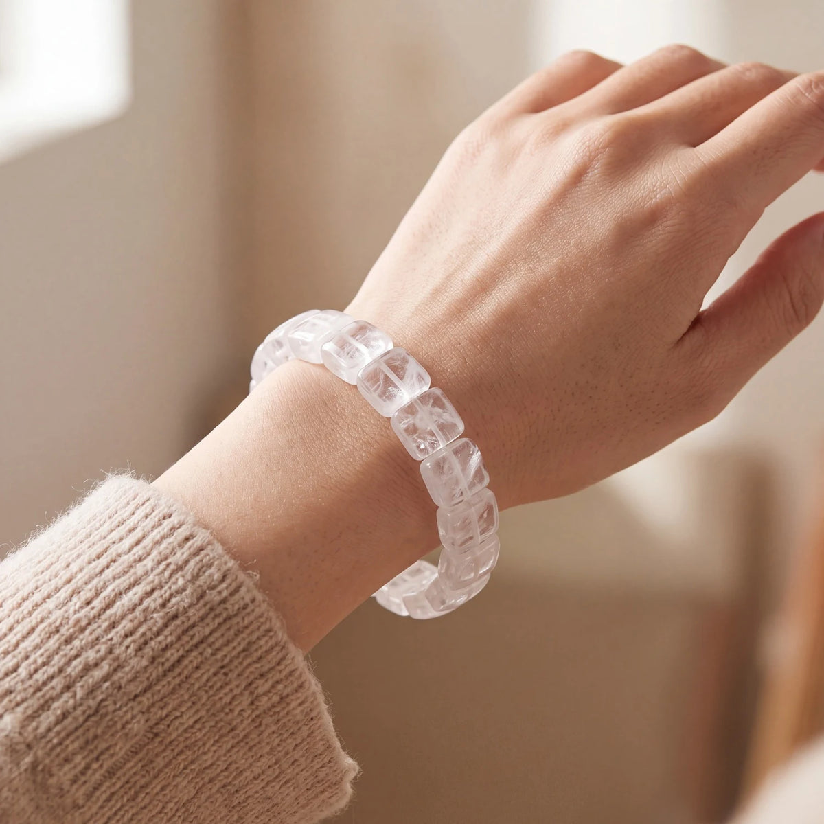 Bracelet pierre transparente en plaques de cristal de roche porté au poignet d'une femme