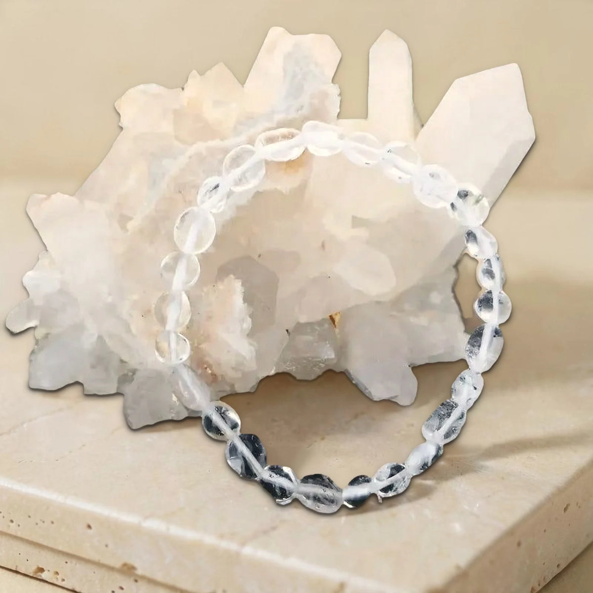 Photo réelle du bracelet cristal de roche en pierre roulée contre un amas de quartz