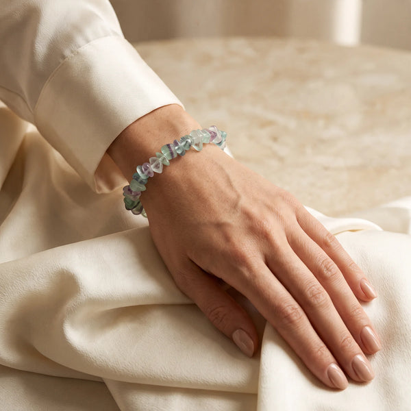 Bracelet fluorine porté par une femme, pierre translucide aux reflets verts et violets