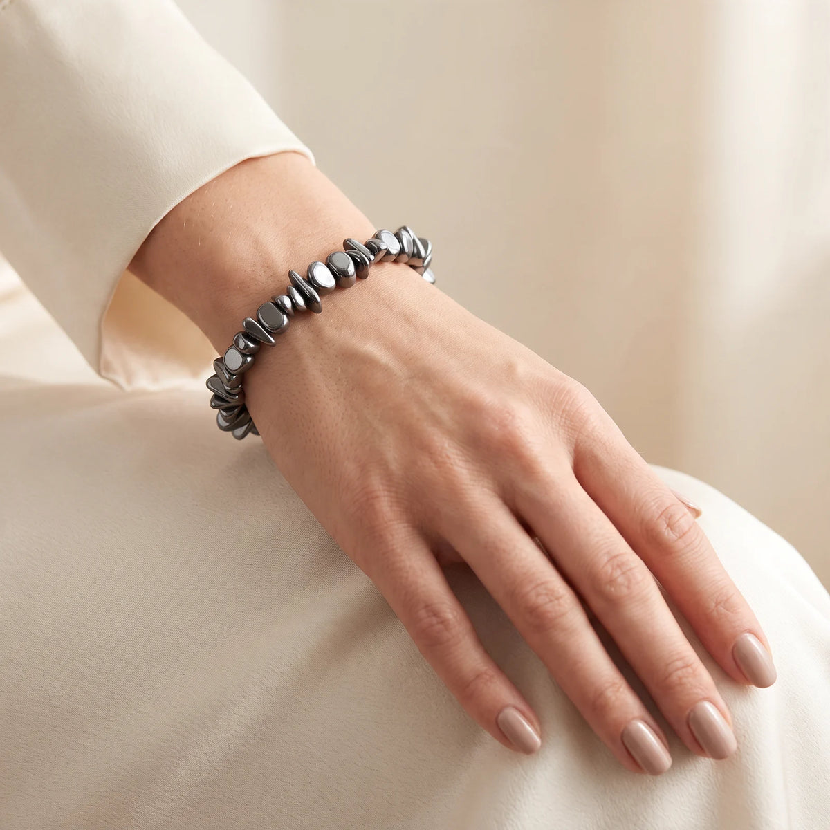 Bracelet hématite porté par une femme, pépites polies aux reflets métalliques