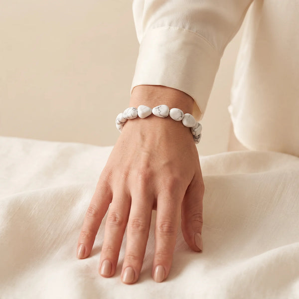 Bracelet howlite porté par une femme, bijou blanc en pierres roulées pour la patience
