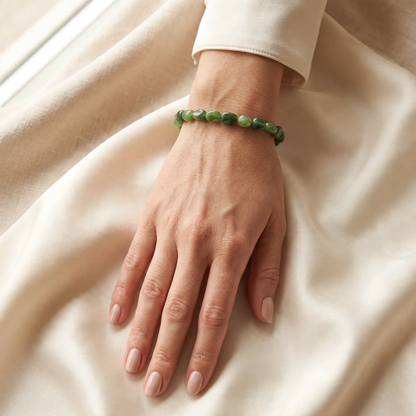 Bracelet jade vert porté au poignet d'une femme, porte-bonheur en pierres roulées