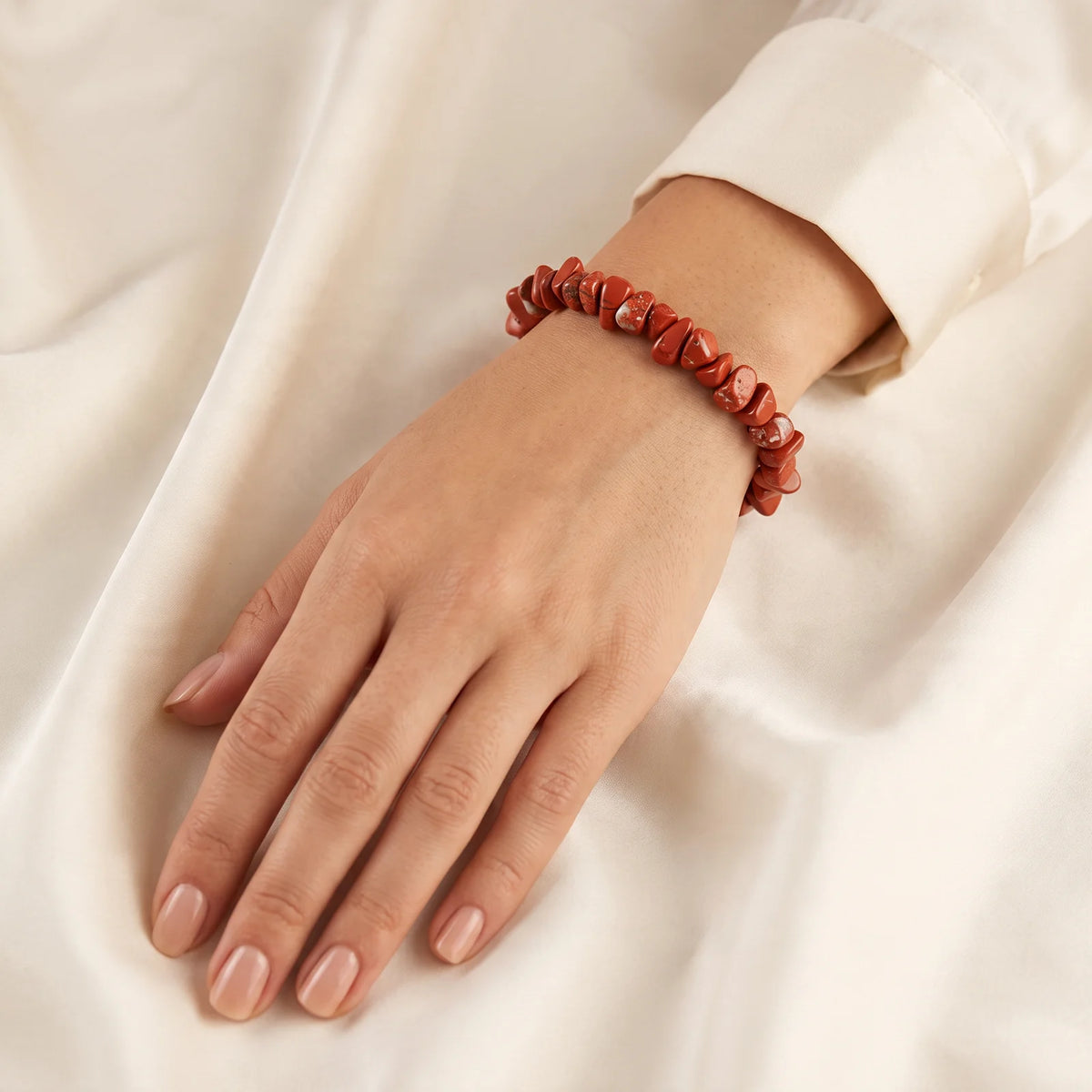 Bracelet jaspe rouge porté au poignet d'une femme, bijou naturel en pépites