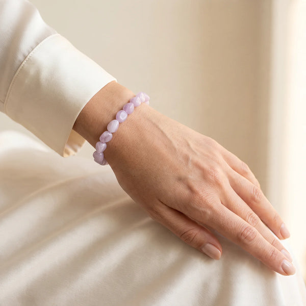 Bracelet kunzite rose porté par une femme, petites pierres roulées lavande au poignet