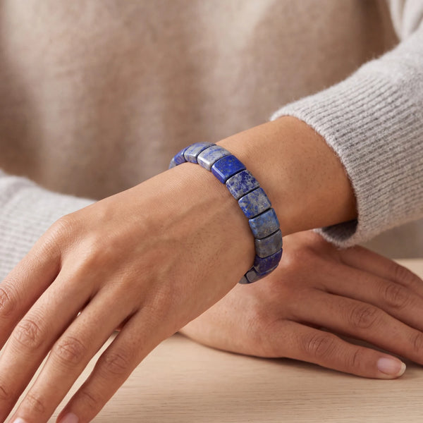 Bracelet pierre bleue en lapis lazuli porté au poignet d'une femme, plaques plates polies
