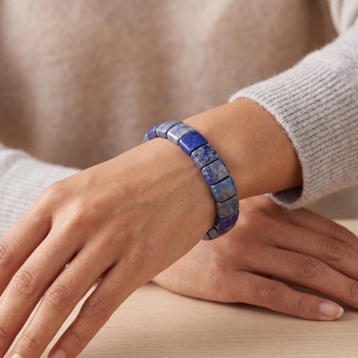 Bracelet pierre bleue en lapis lazuli porté au poignet d'une femme, plaques plates polies