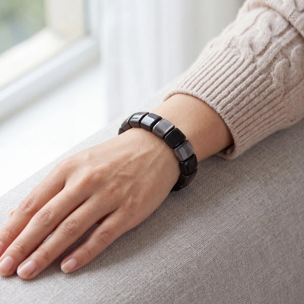 Bracelet en obsidienne argentée porté par une femme, plaques noires polies au reflet métallisé