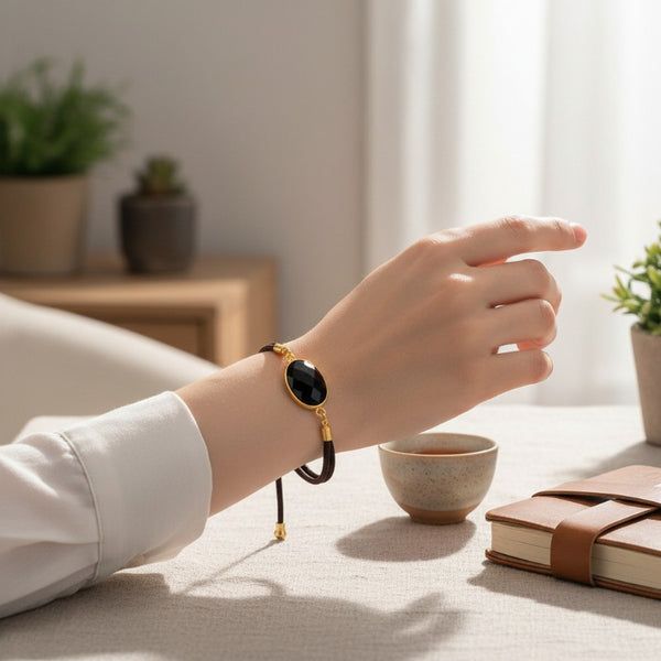 Bracelet Obsidienne noire ÉCLIPSE® porté au poignet, bijou fin avec pierre ovale facettée