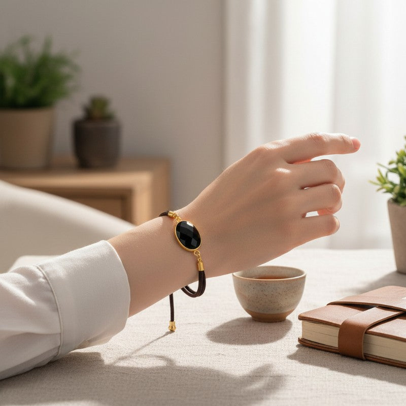 Bracelet Obsidienne noire ÉCLIPSE® porté au poignet, bijou fin avec pierre ovale facettée