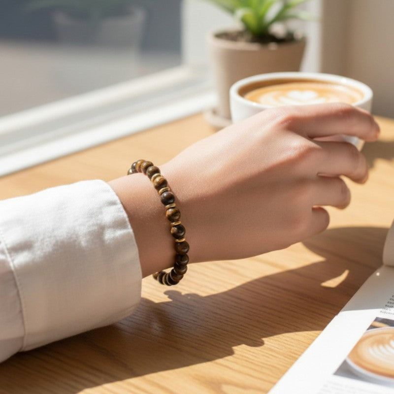 Bracelet Œil de tigre AURA® porté au poignet, bracelet fin doré en pierre naturelle