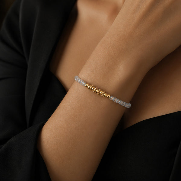 Bracelet pierre aigue-marine FINA® porté au poignet d'une femme, perles facettées et perles dorées