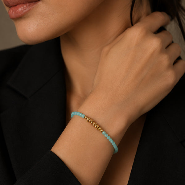 Bracelet pierre amazonite FINA® porté au poignet d'une femme, perles facettées et perles dorées