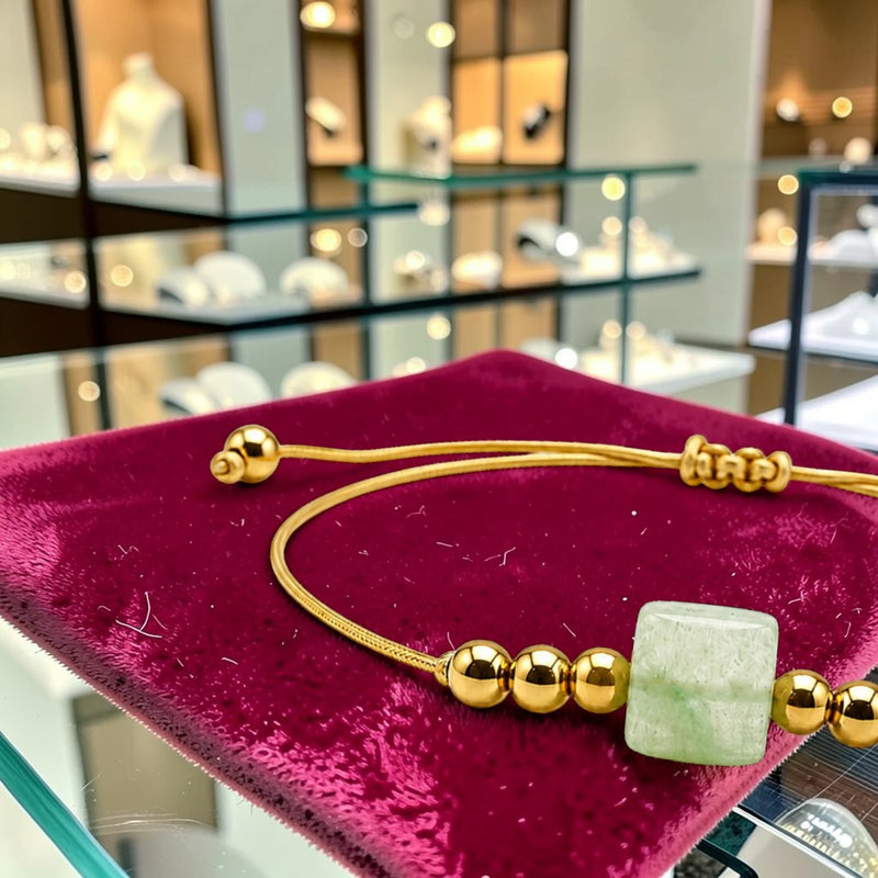 Gros plan de la pierre cube 8 mm en aventurine verte du bracelet cordon doré CUBE®, paillettes scintillantes